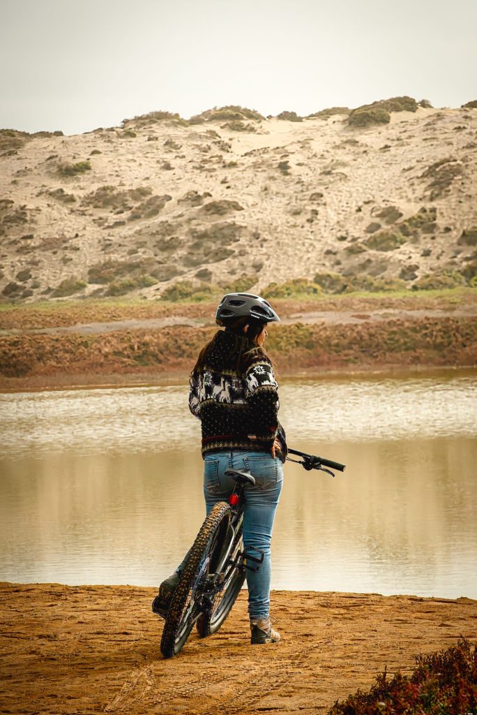 Visitante mirando la laguna del Humedal La Boca con las dunas al fondo